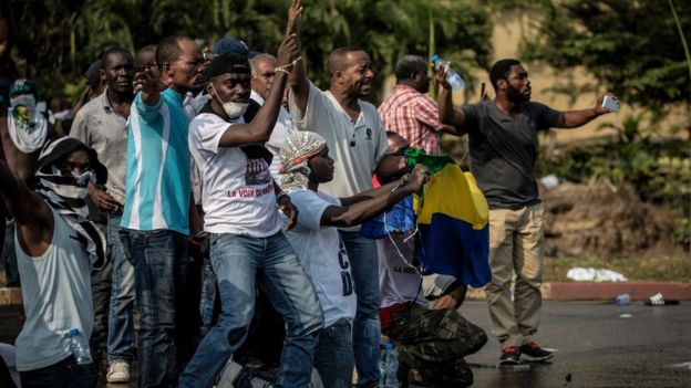 Οι υποστηρικτές του γκαμπονέζικου μεταλλικού θόρυβου του Jean ηγετών αντίθεσης αντιμετωπίζουν τις δυνάμεις ασφάλειας