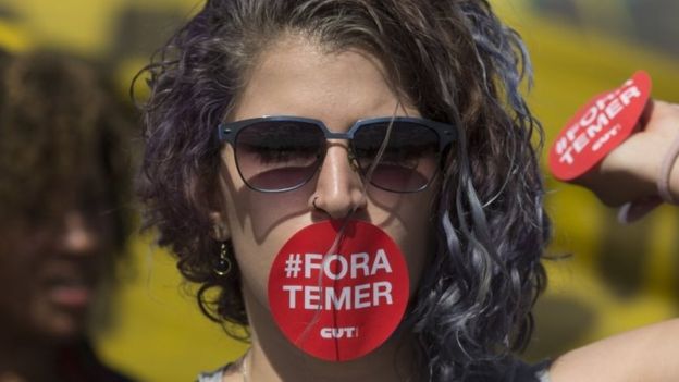 Ένας υποστηρικτής Dilma Rousseff, το στόμα της που καλύπτεται με μια αυτοκόλλητη ετικέττα που διαβάζει στα πορτογαλικά